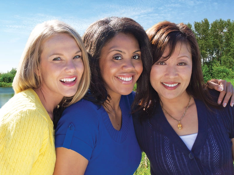 Three woman standing side by side smiling