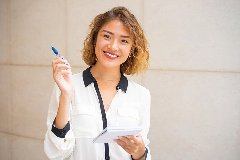 Woman smiling taking notes
